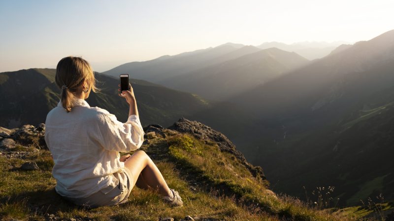 woman-taking-selfie-on-mountain-side-view